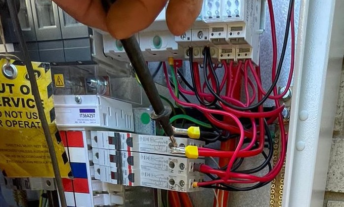 Electrician inspecting safety switch in switchboard